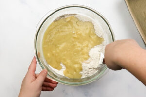 Mixing wet and dry ingredients together in a bowl for banana bread